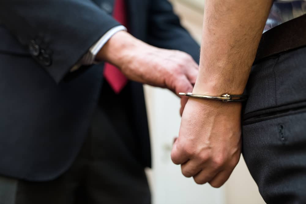 Agent arresting a businessman. Source: Shutterstock.com