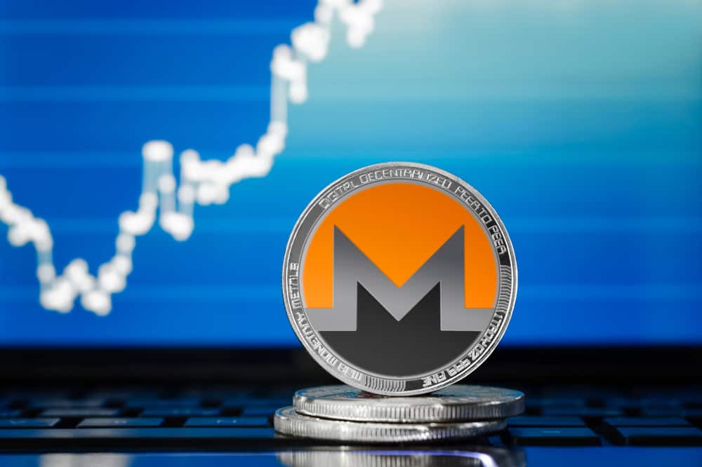Silver monero coin on the background of the chart. Shutterstock.com
