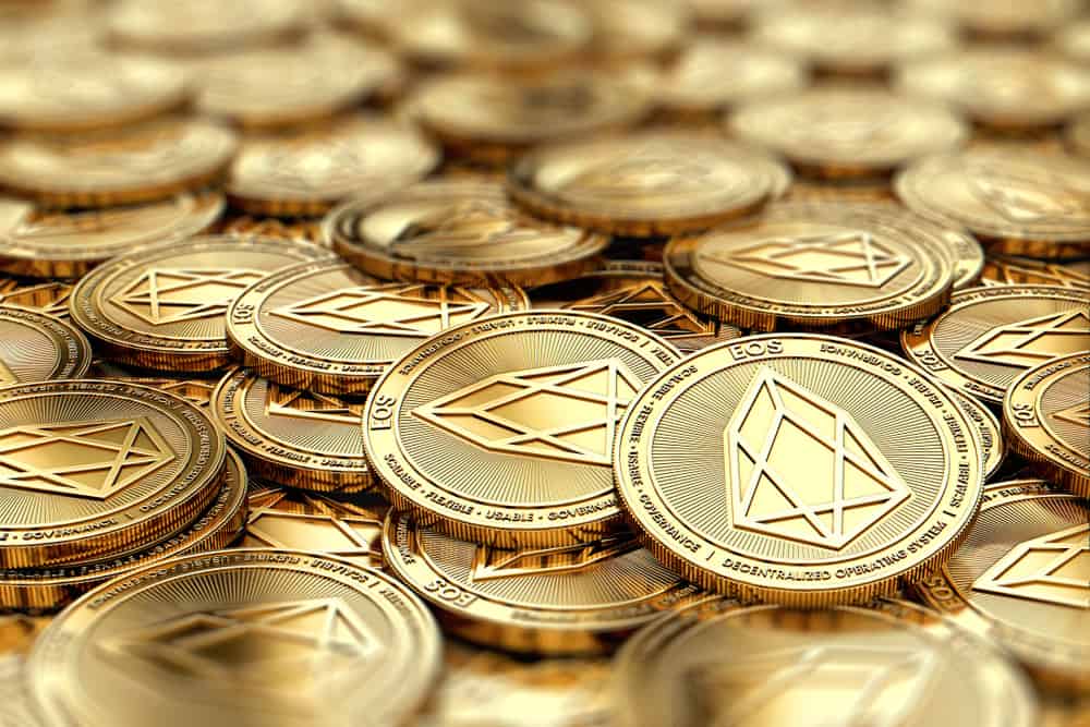 Stack of golden EOS coins in blurry closeup with copy space above in blurred area. Source: Shutterstock.com