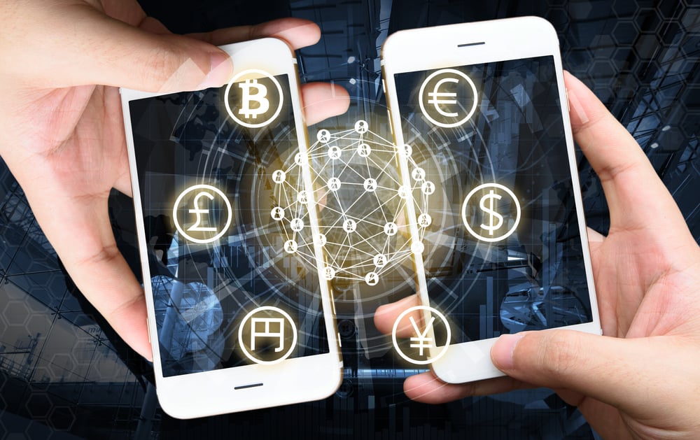 Two Businessman hands holding smartphones. Fintech concept , Peer-to-peer concept with map and world connect , hi-tech building abstract background. Source: shutterstock.com