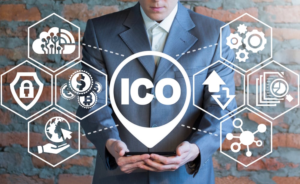 A man holding a smartphone with ICO. Source: Shutterstock.