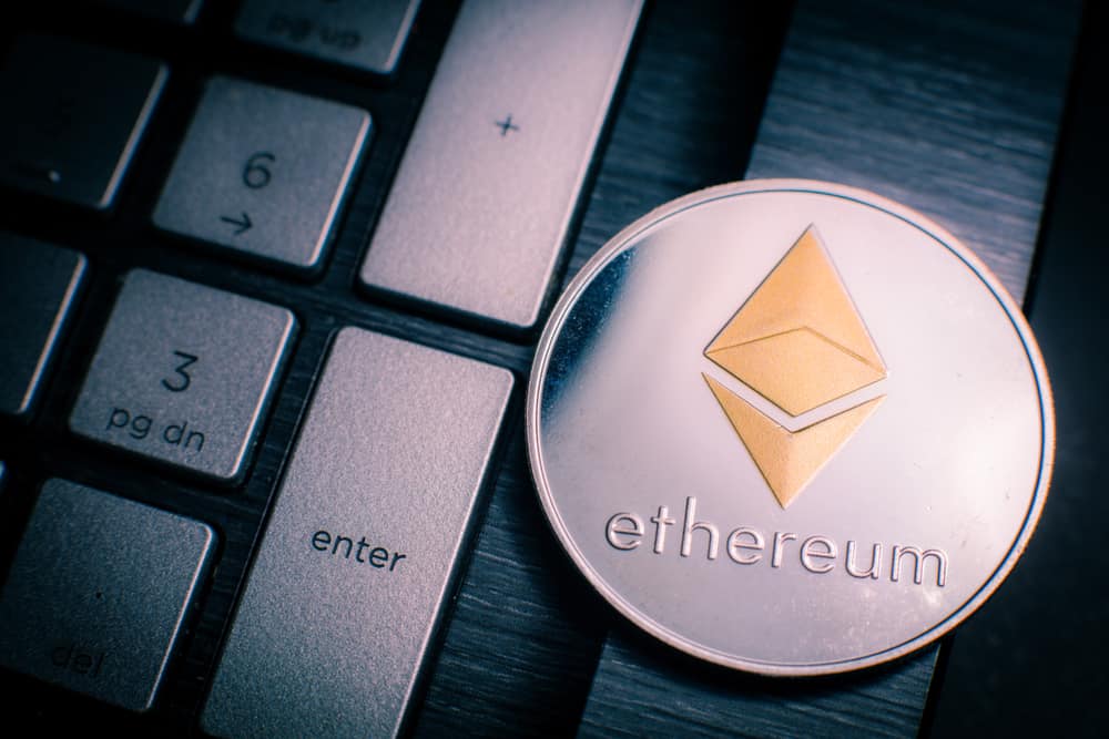 Ethereum cryptocurrency (crypto currency). Silver Ethereum coin with gold Ethereum symbol on a laptop keyboard next to the Enter key. SOurce: shutterstock.com