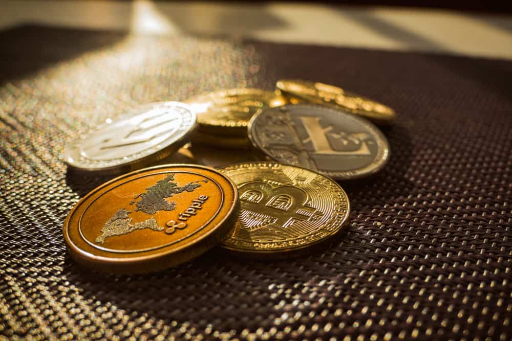 Family of cryptocurrency. Stack of shining golden and silver coins with sunlight on background. Crypto group. Ripple and litecoin dominance, Warm colours - photo of crypto coins. Source; shutterstock.com