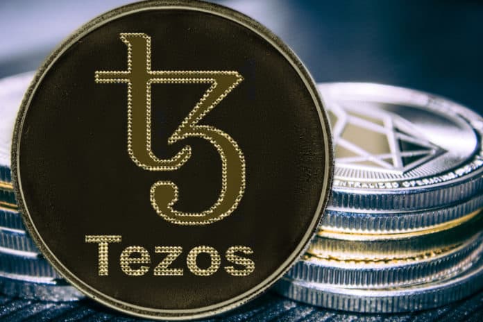 Coin cryptocurrency Tezos on the background of a stack of coins. XTZ coin. - Image
